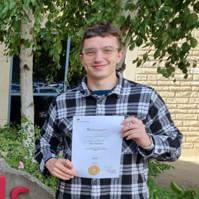 Ross Bickerton holding up a Digital Marketing Level 6 Apprenticeship Degree Certificate in Digital Marketing