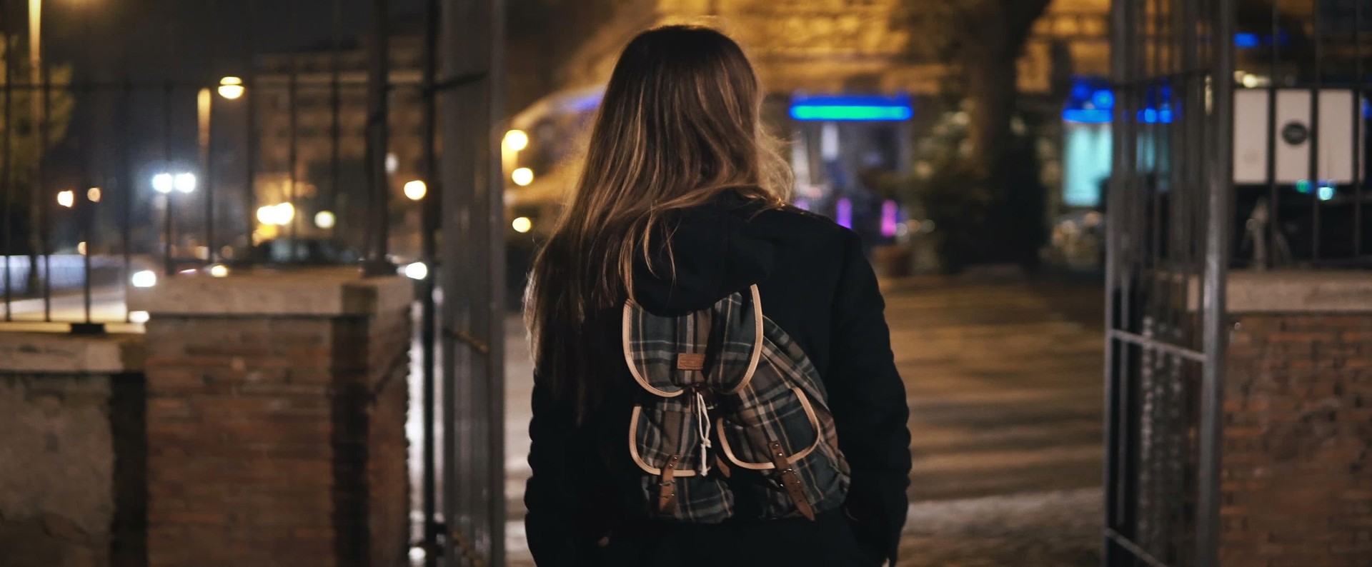 A female walking with a rucksack on in the dark