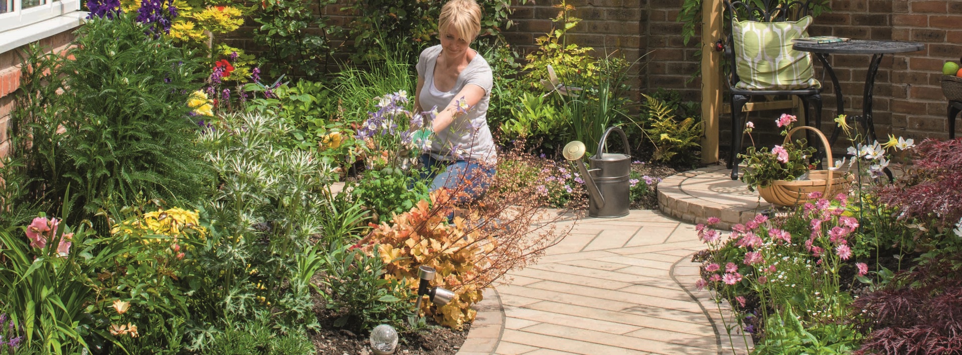 Marshalls Sawn Versuro linear used on a pathway with lots of greenery and a homeowener gardening in the background