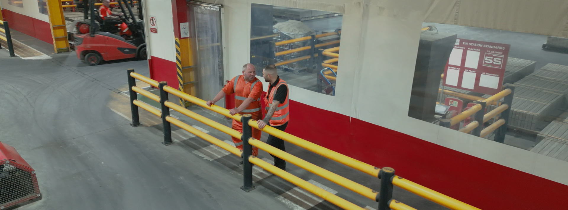 Marshalls staff talking to each other behind a yellow safety bar 