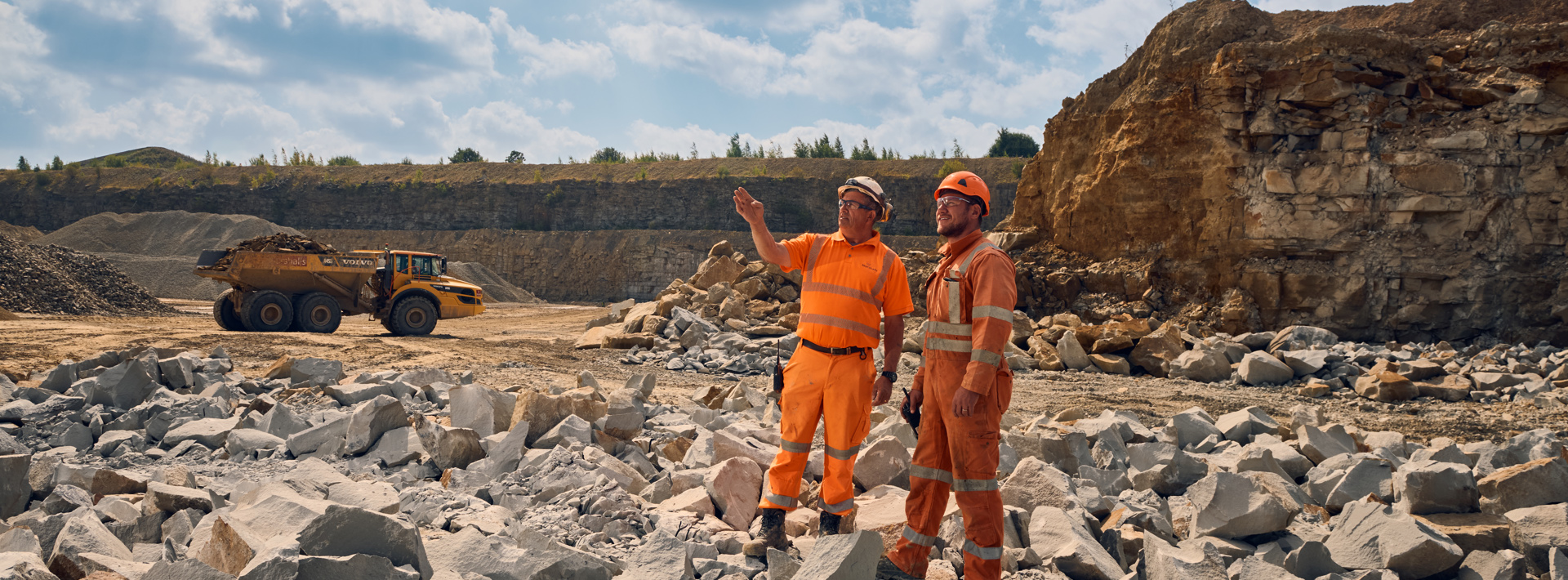 Staff members on site in high vis workwear looking over at the trucks