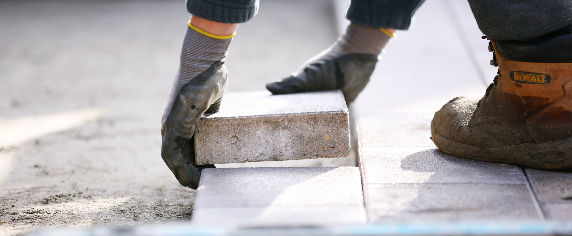 A landscaper laying blocks on a driveway